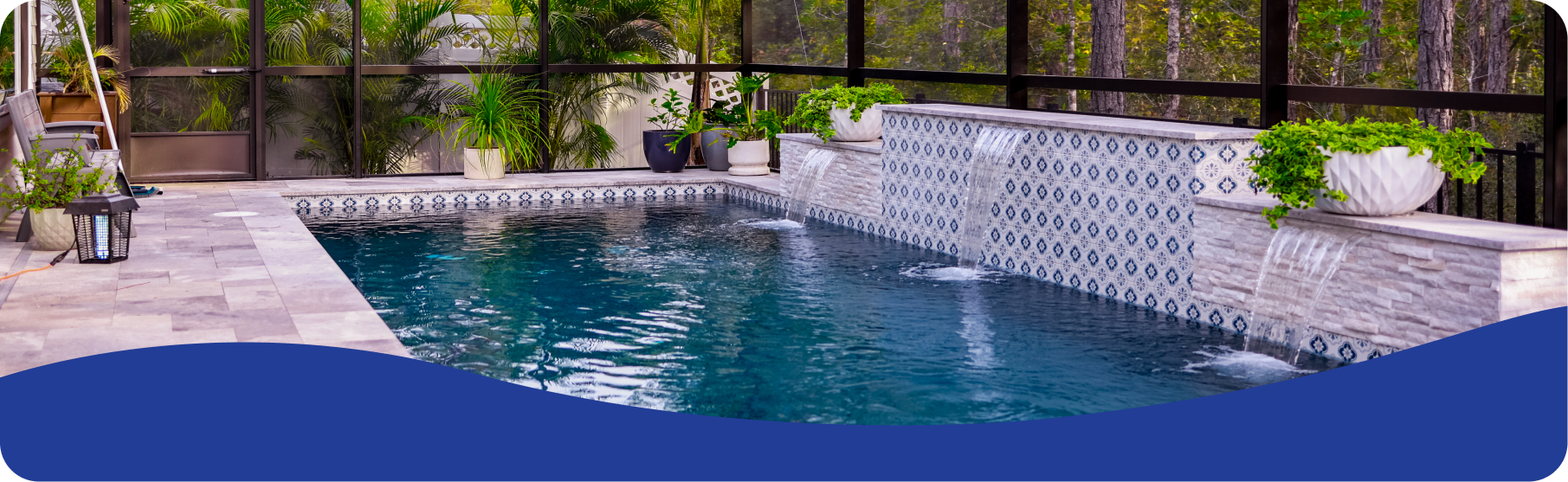 A blue swimming pool with a decorative tiled water feature and stone patio inside a screened enclosure.