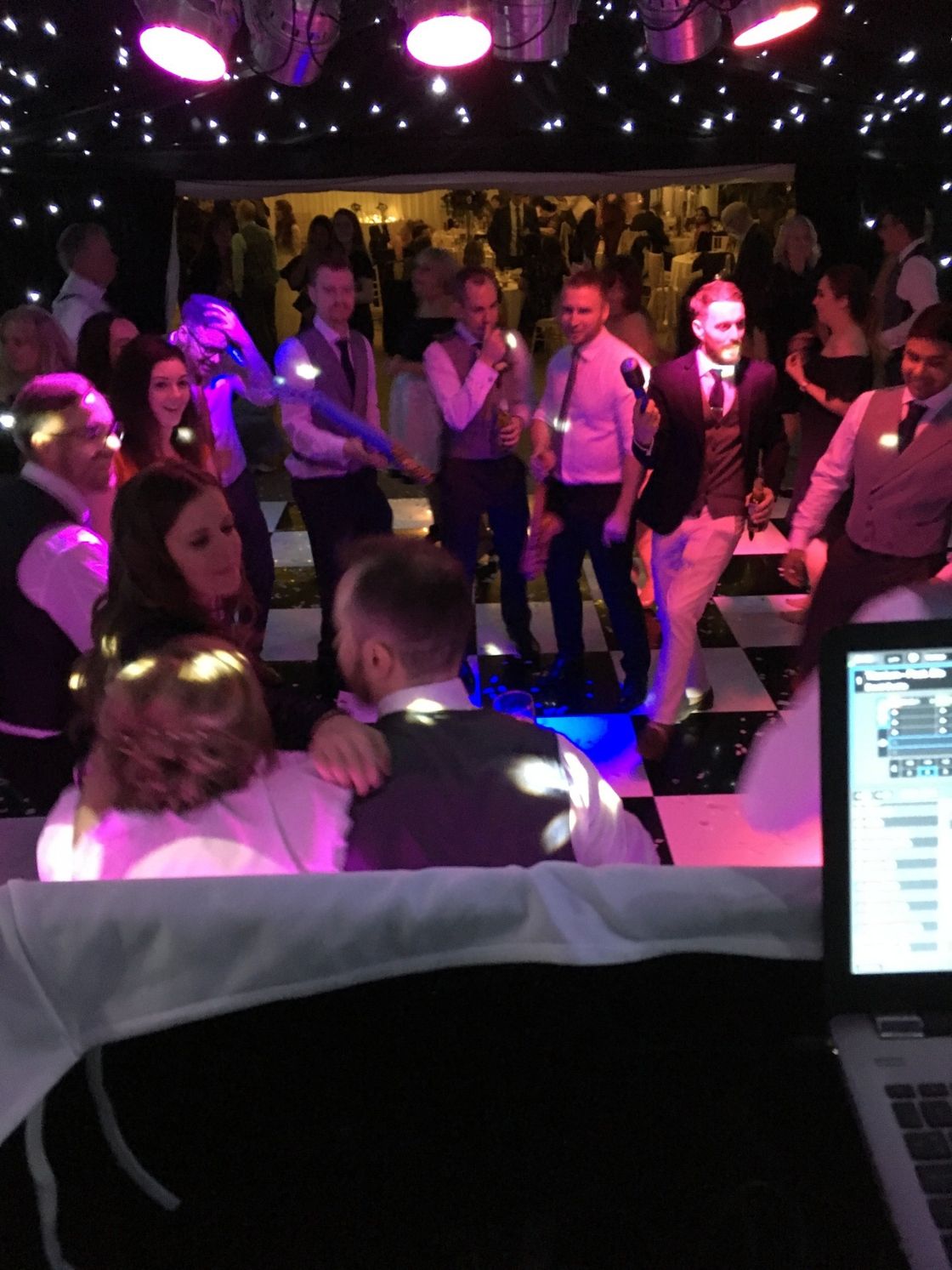 view from the DJ console of the dance floor with bride and groom dancing