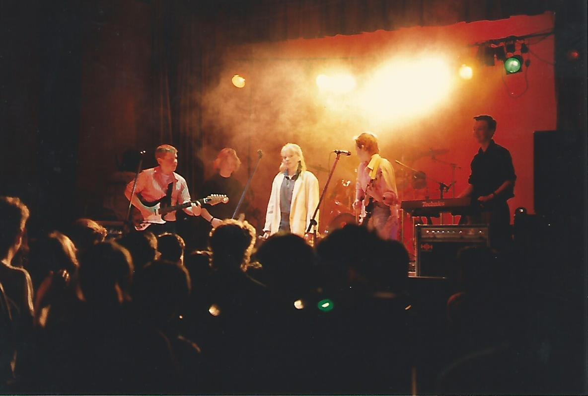 live band playing on stage with lighting and smoke effects