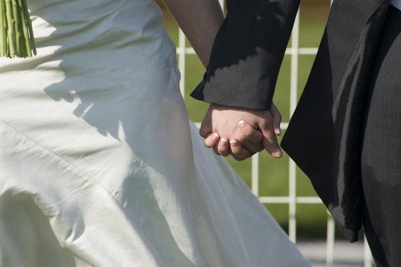 bride and groom holding hands. Just married