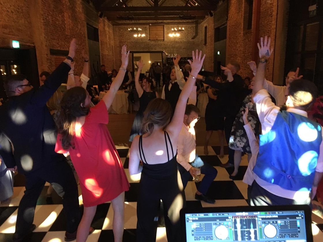 Dance floor in full swing with  hands in the air.