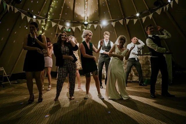 wedding bride, groom and family dancing in yurt