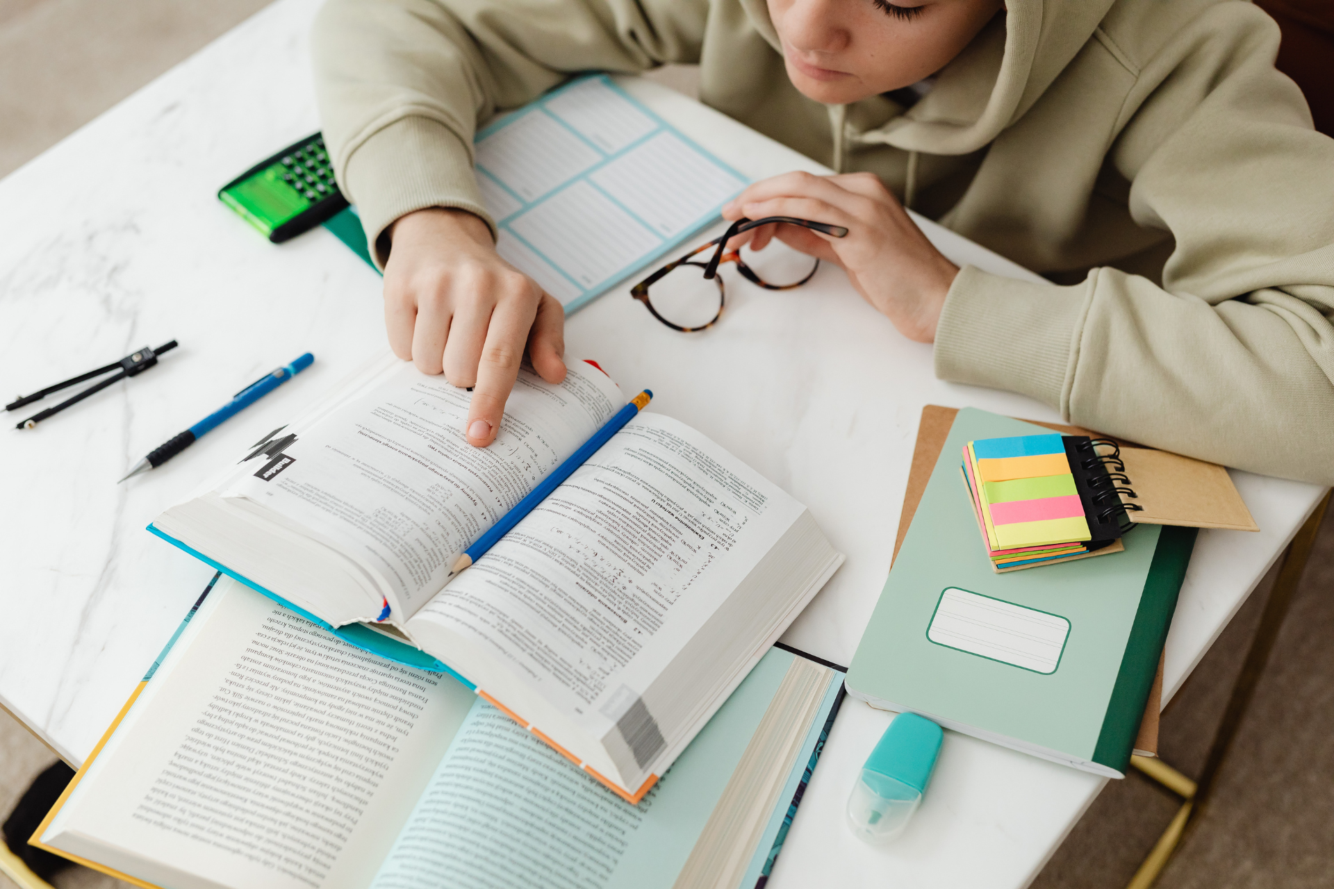 A person is sitting at a table reading a book.