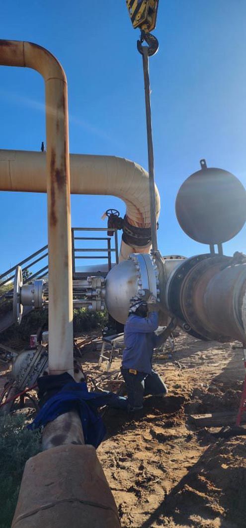 A man is working on a pipe with a crane.