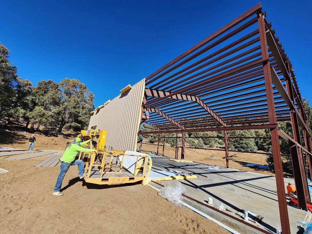 A man is standing in front of a large metal structure.