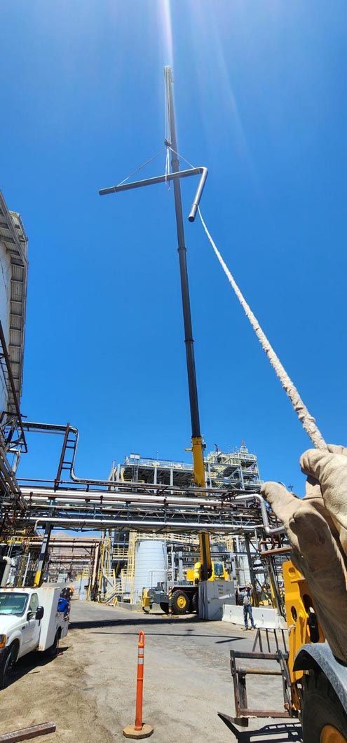 A person is standing next to a crane in a parking lot.