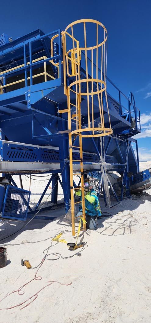A man is standing in front of a building with a ladder attached to it.