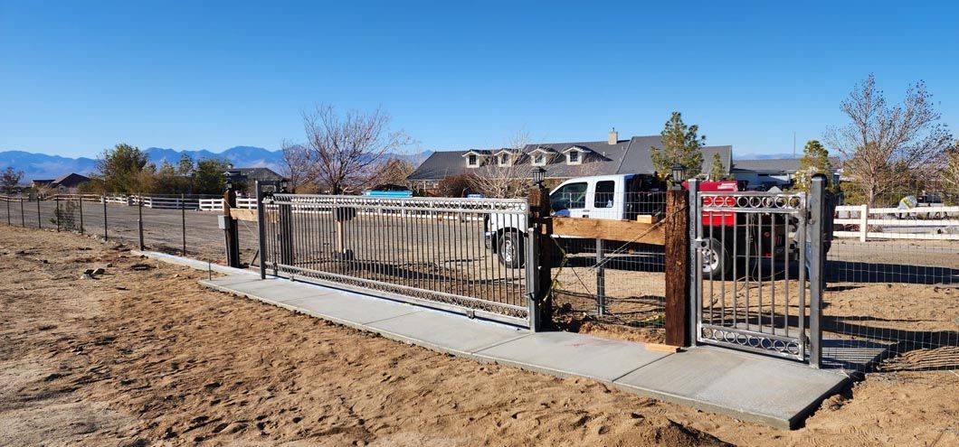 A fence with a walkway leading to a house in the background.