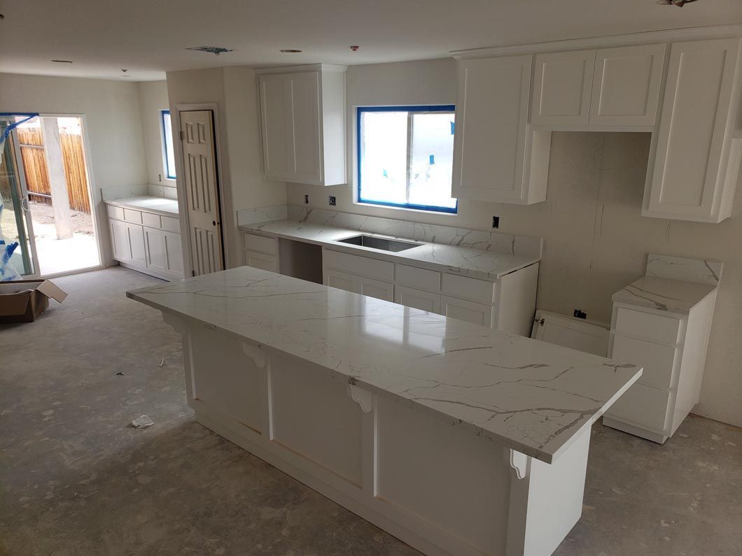 A kitchen with white cabinets and white counter tops