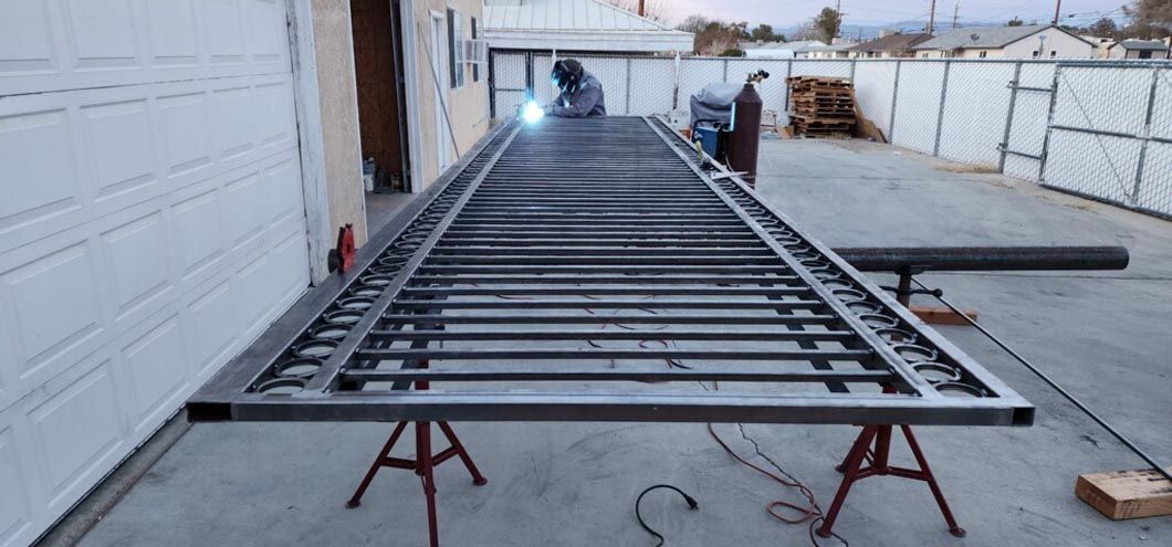 A man is welding a metal structure in a garage.