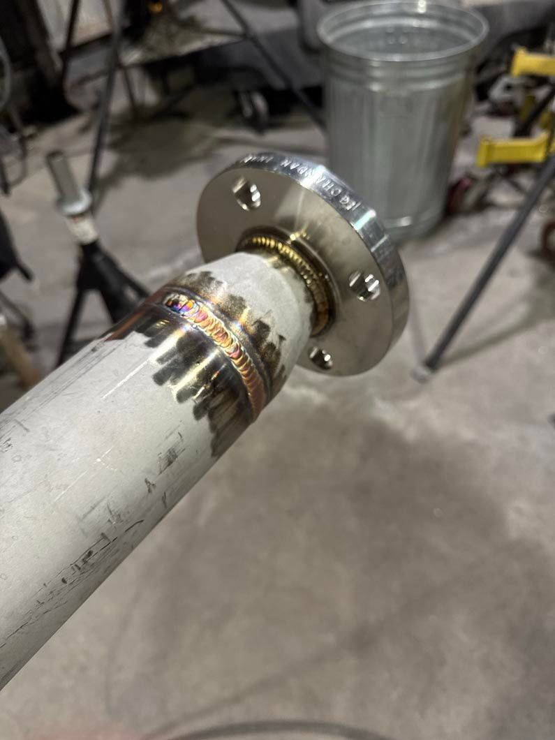 A close up of a metal pipe with a flange on it.