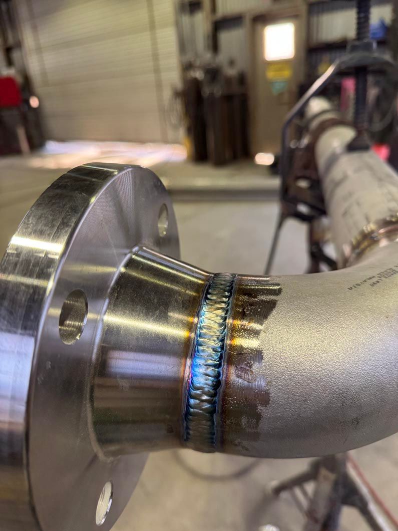 A close up of a metal pipe with a flange on it.