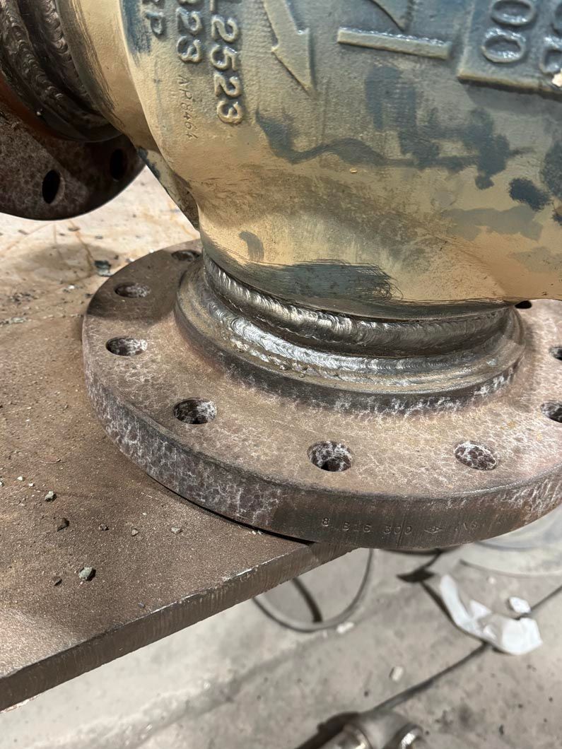 A close up of a metal pipe sitting on top of a wooden table.