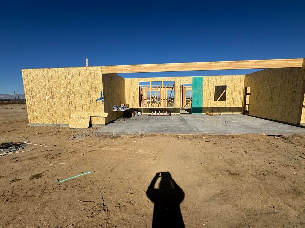 A person is taking a picture of a house under construction.