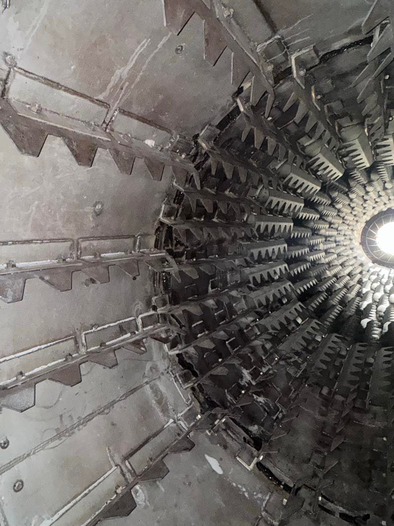 A close up of a metal structure with a light shining through it.