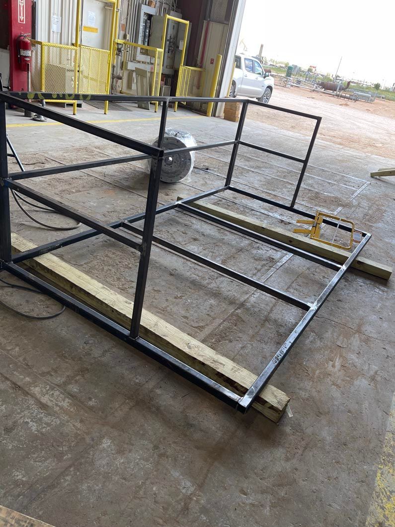 A metal frame is sitting on the ground in a garage.