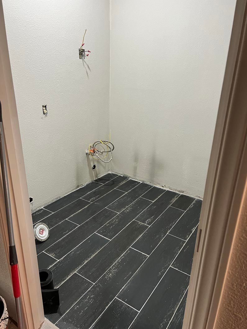 A room with a black tile floor and white walls.