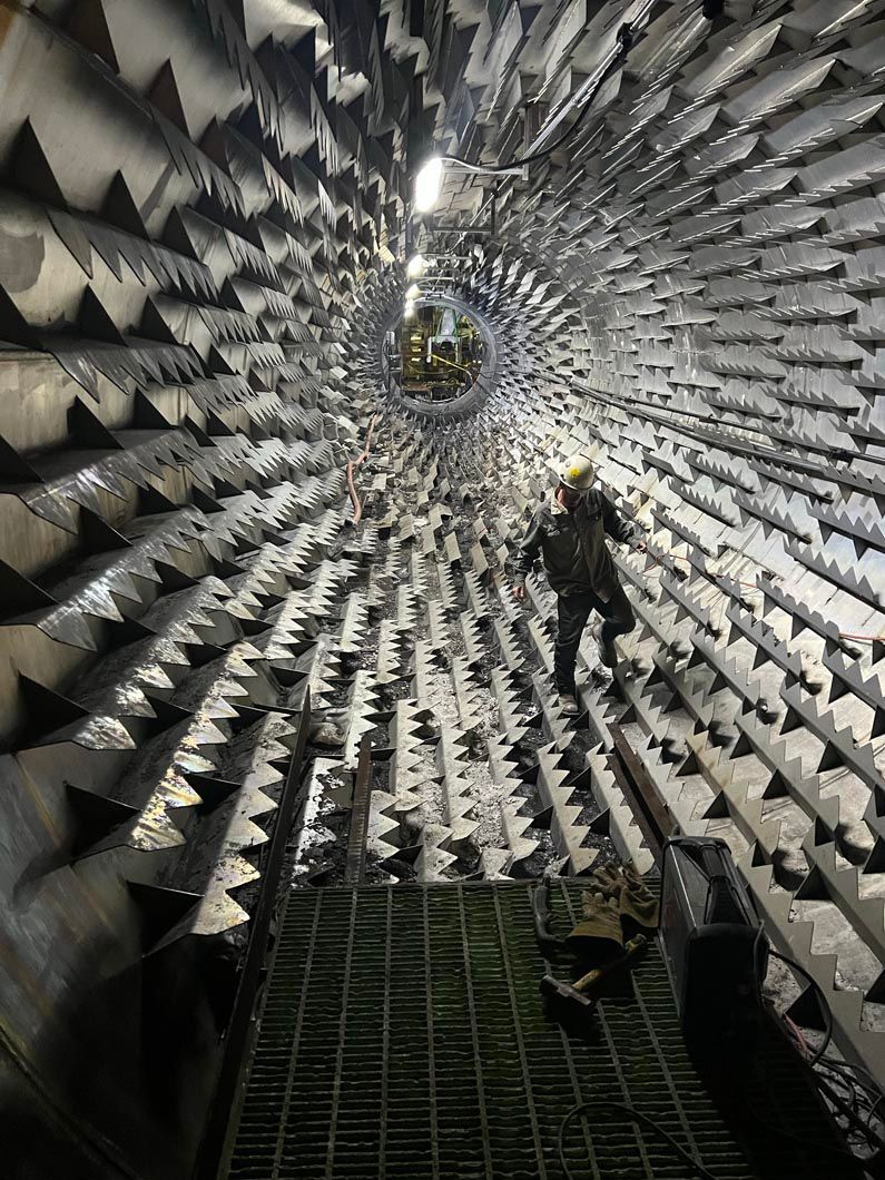 A man is standing in the middle of a tunnel with a lot of stairs.