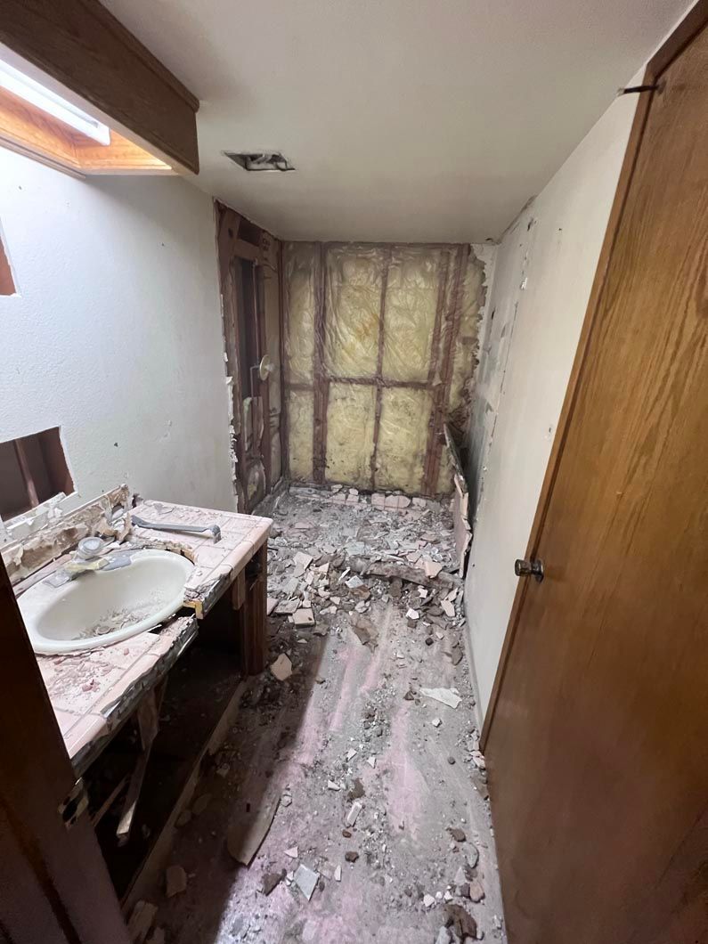 A bathroom with a sink and a door that is being remodeled.