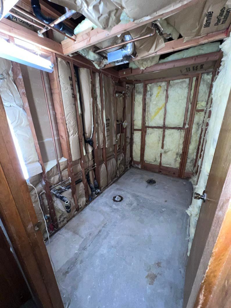 A bathroom under construction with wooden walls and a concrete floor.