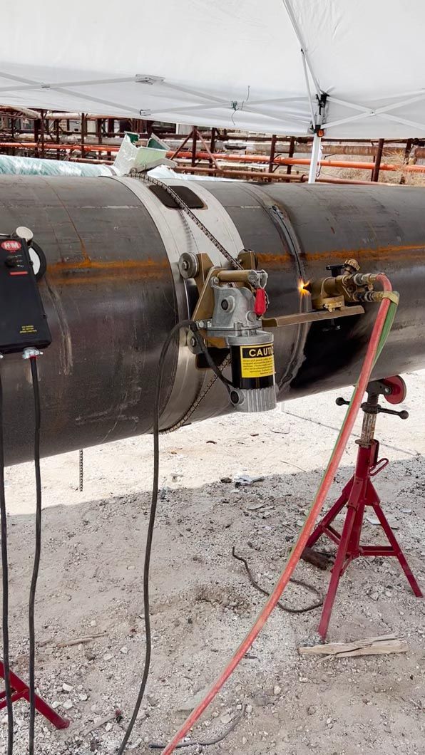 A person is welding a pipe on a construction site.