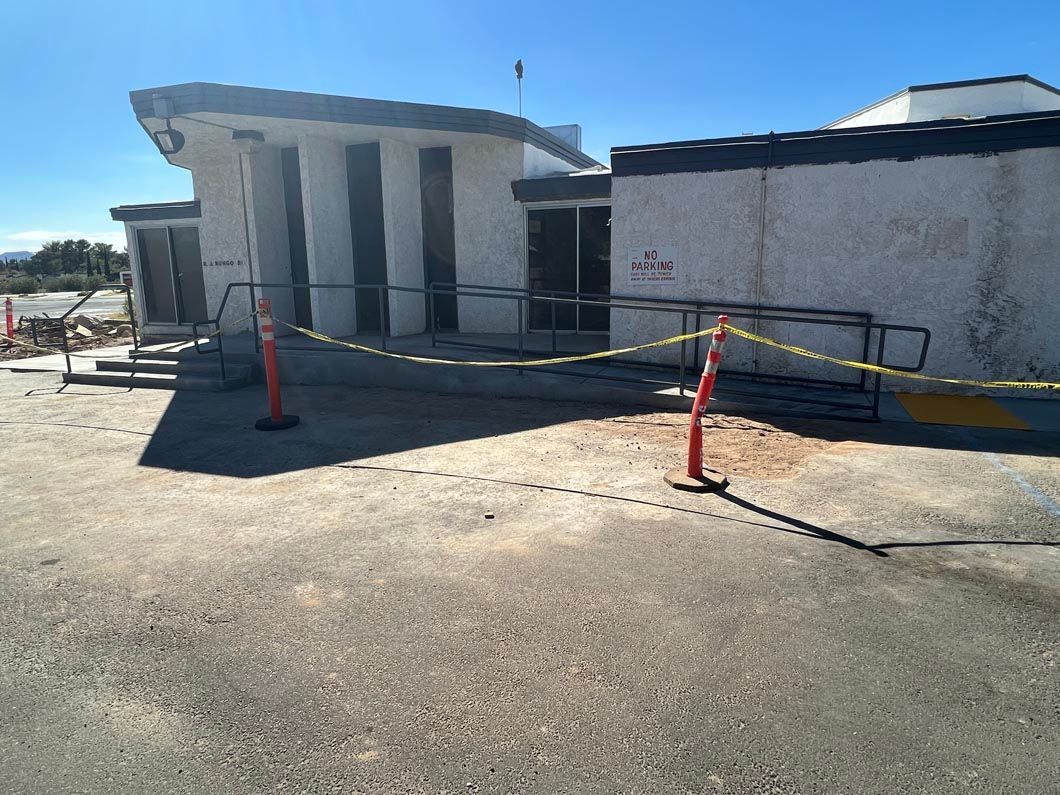 A white building with a yellow tape fence around it