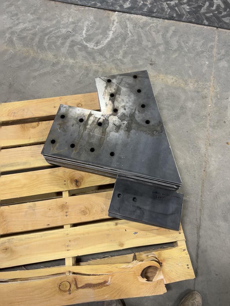 A piece of metal is sitting on top of a wooden pallet.