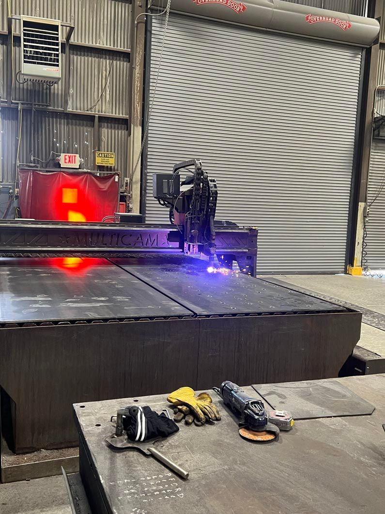 A machine is cutting a piece of metal in a factory.