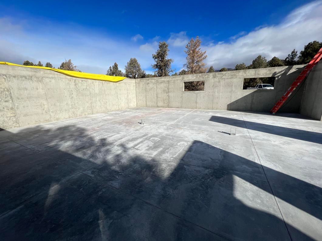 A large concrete wall with a yellow tarp on top of it.