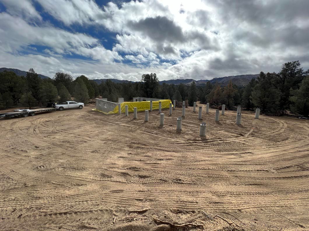 A row of yellow tents are sitting in the middle of a dirt field.