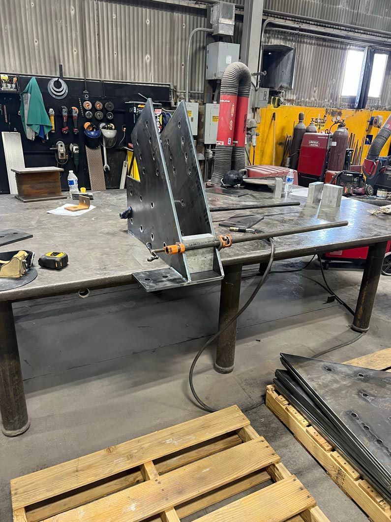 A welding table with a piece of metal on it in a factory.