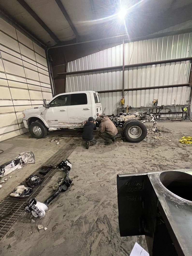 A white truck is being worked on in a garage.