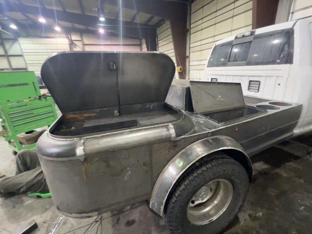 A truck with a trailer attached to it is sitting in a garage.