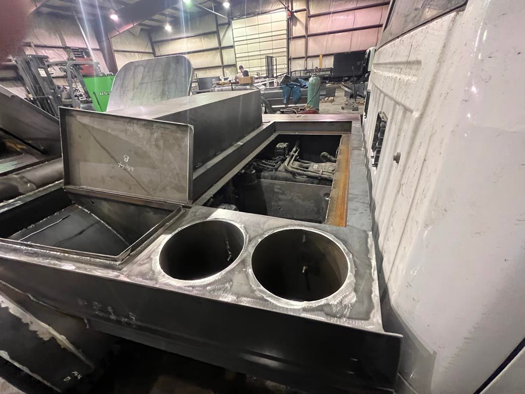 A stainless steel container with two holes in it is in a warehouse.