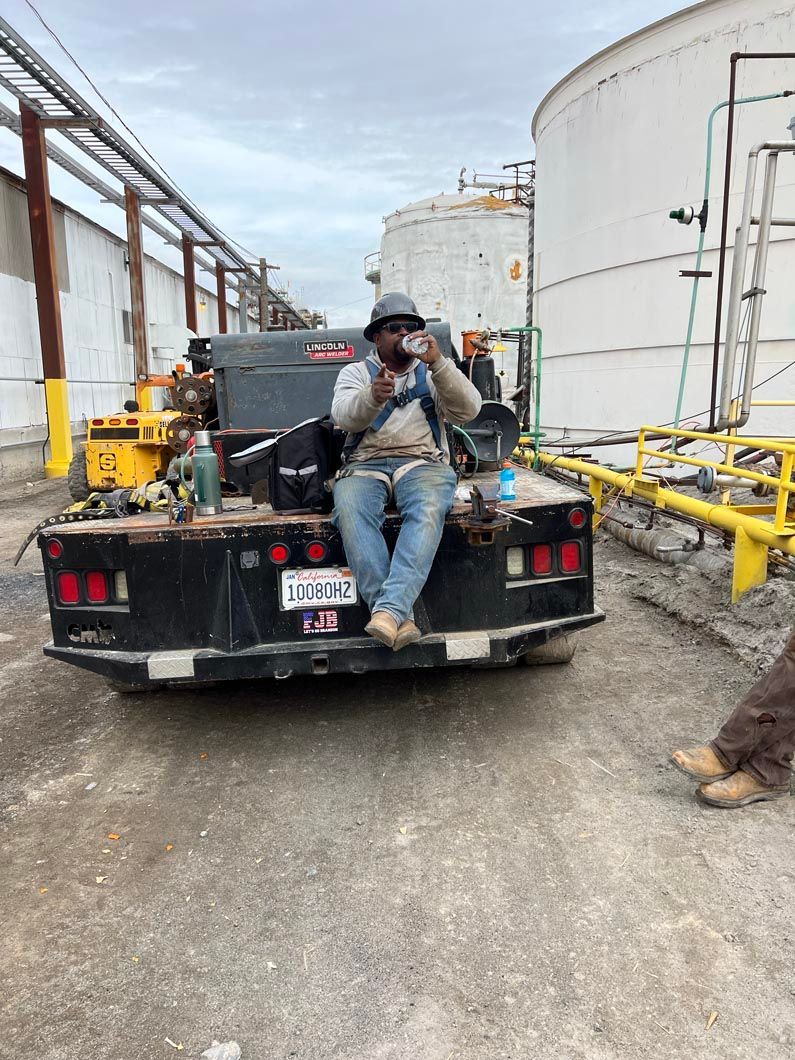 A man is sitting on the back of a truck taking a picture.