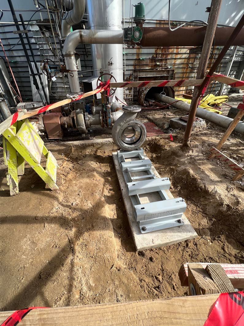 A ladder is sitting on top of a pile of dirt in a construction site.