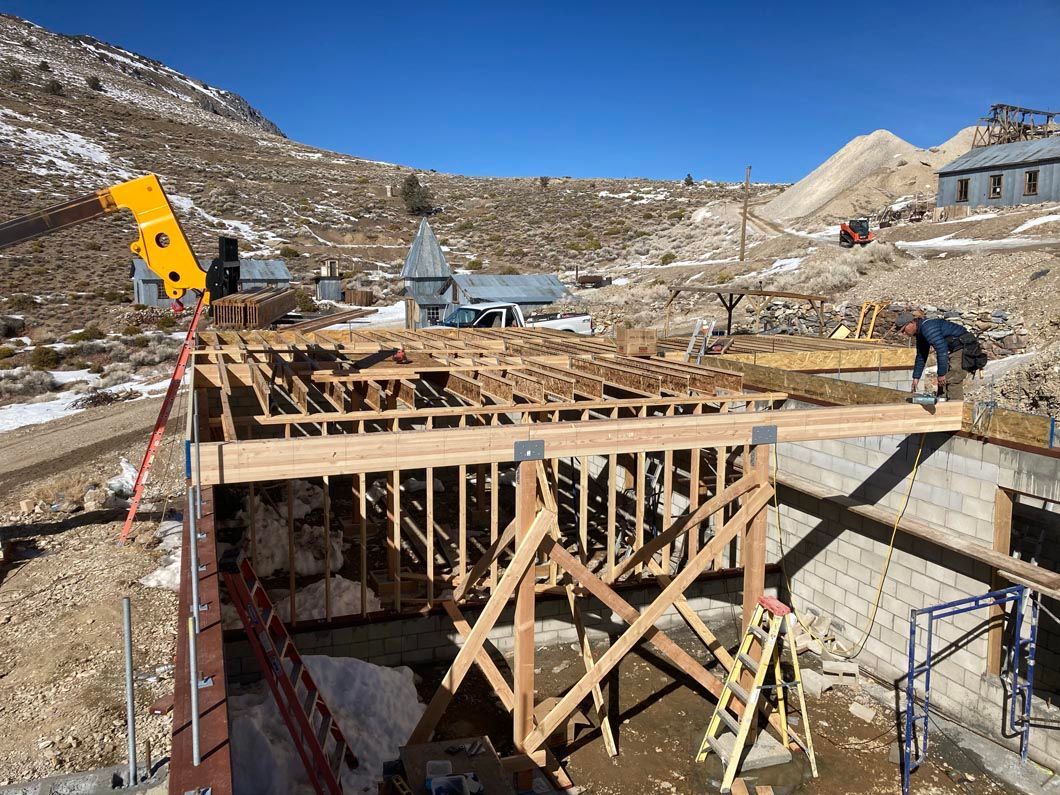A large wooden structure is being built in the middle of a mountain.
