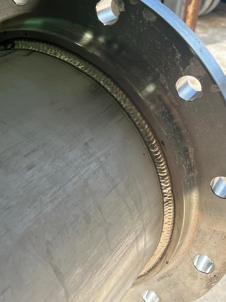 A close up of a metal pipe with a flange on it.