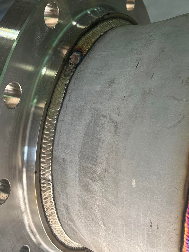 A close up of a metal pipe with a flange on it.