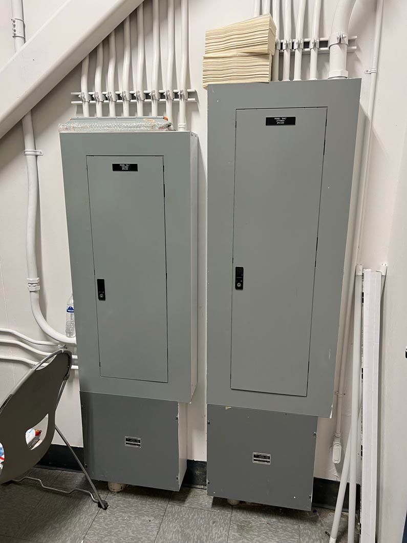 Two electrical boxes are sitting next to each other in a room.