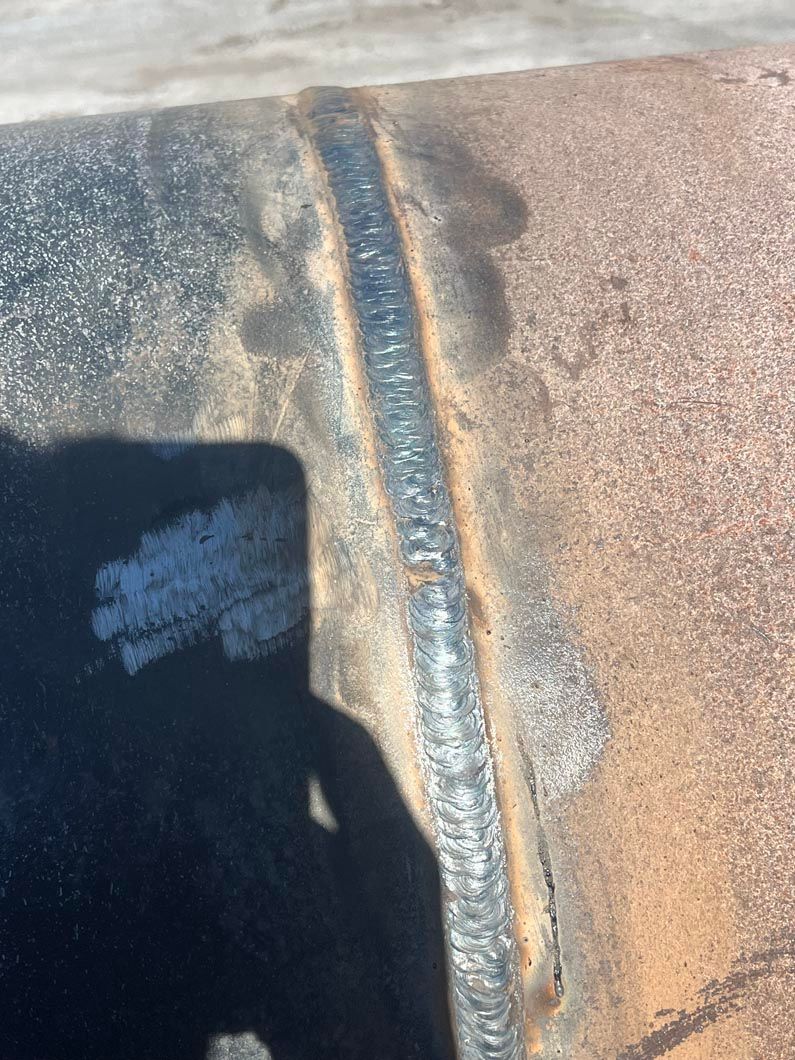 A shadow of a person is cast on a piece of metal.