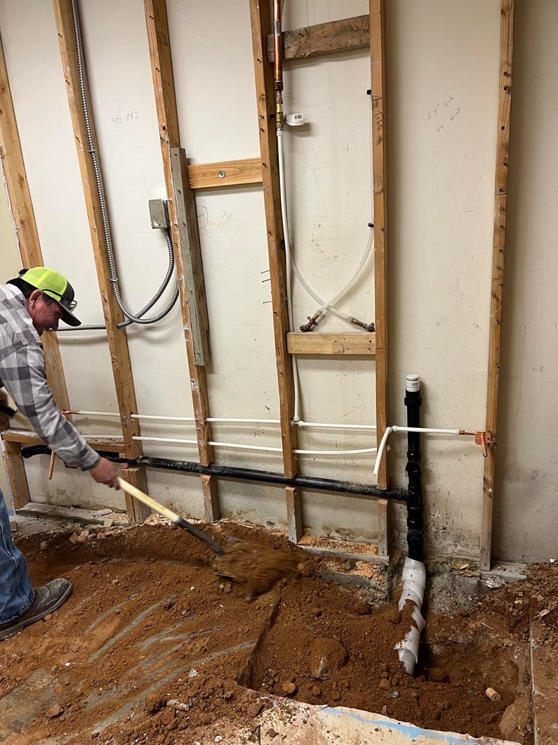 A man is digging a hole in the ground in a room.