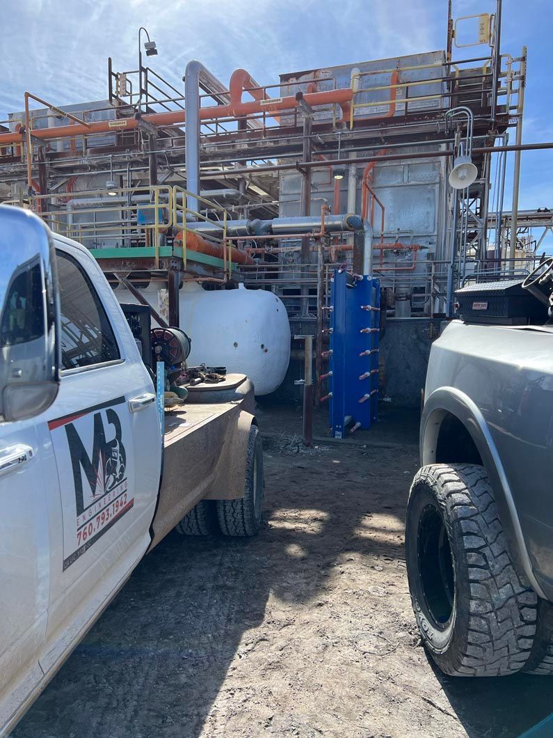 Two trucks are parked in front of a large building.