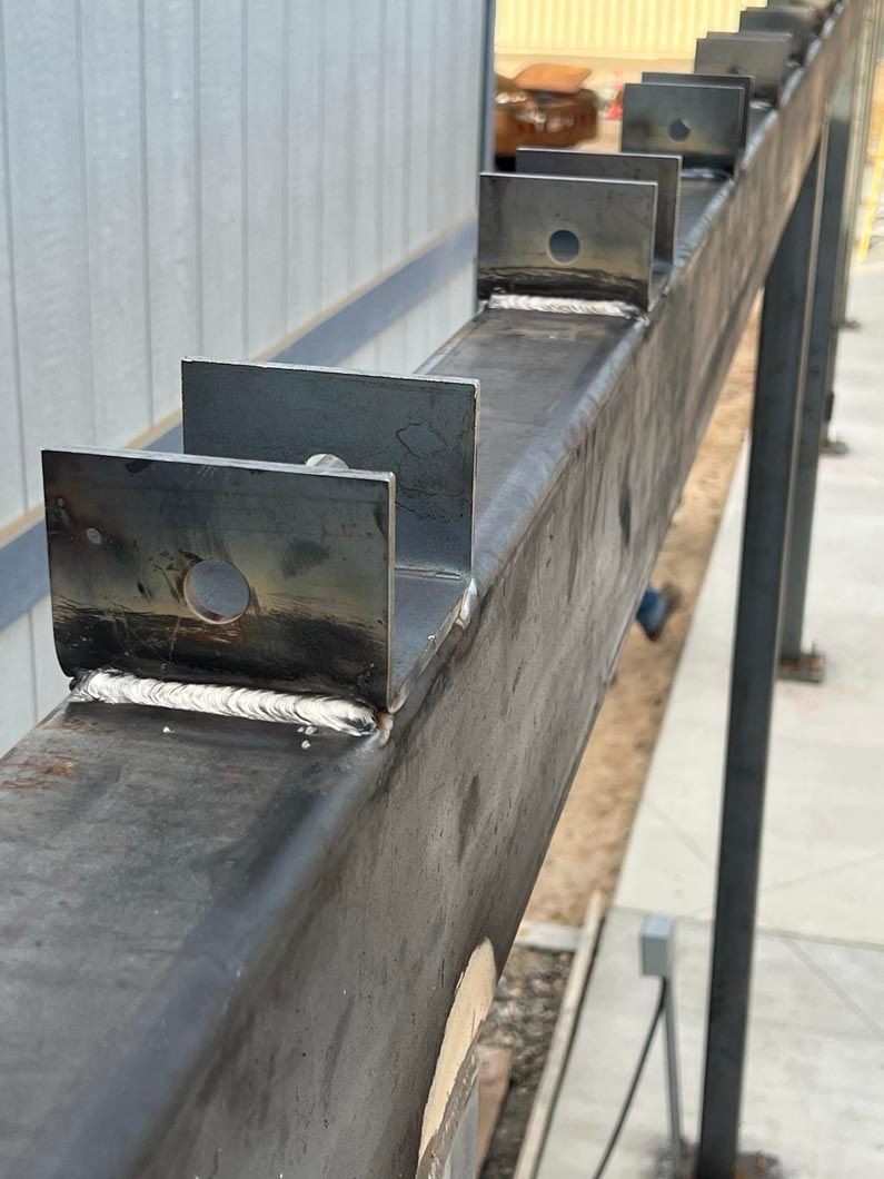 A row of metal beams are sitting next to each other on a concrete surface.
