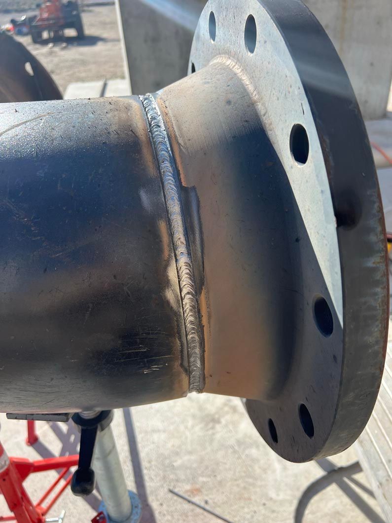 A close up of a metal pipe with a flange on it.