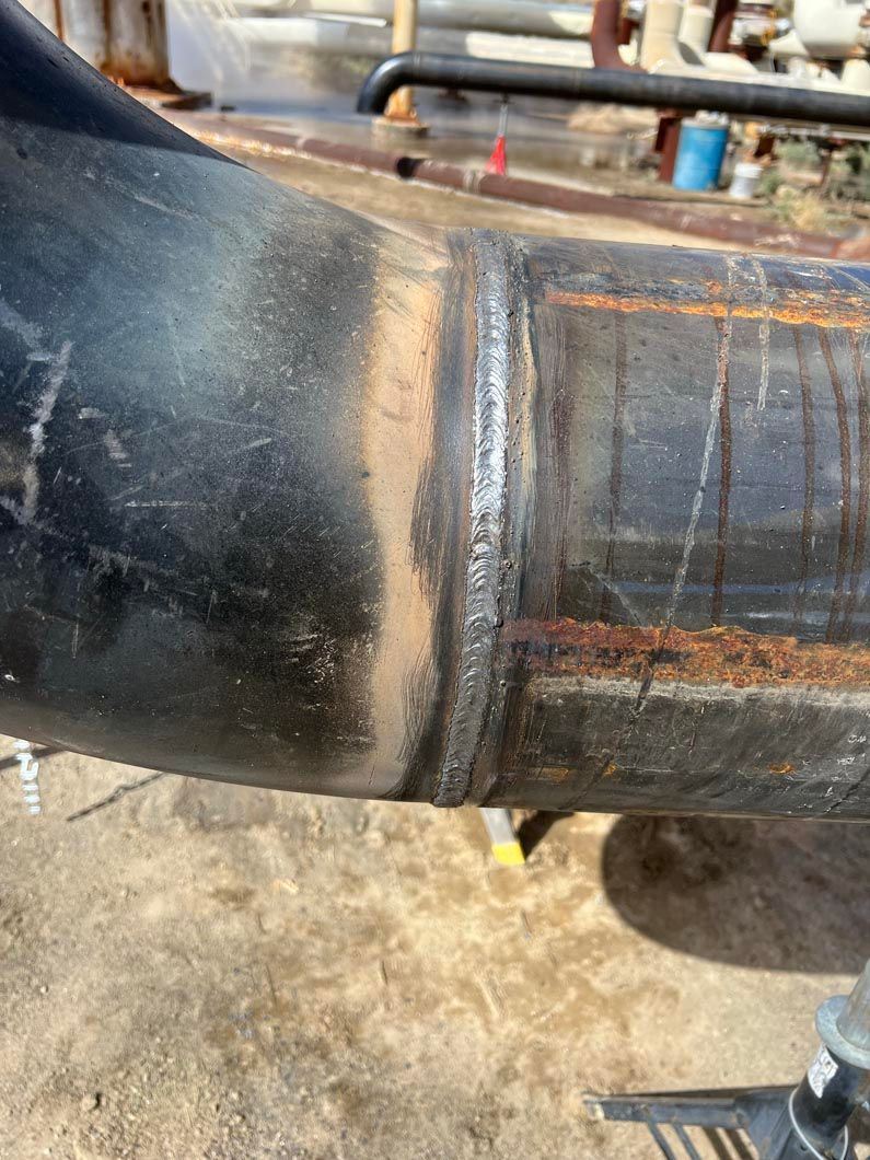 A close up of a metal pipe with a weld on it.