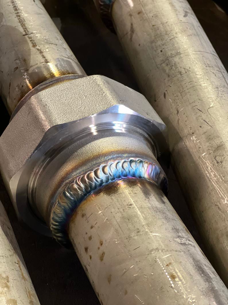 A close up of a welding job on a metal pipe.
