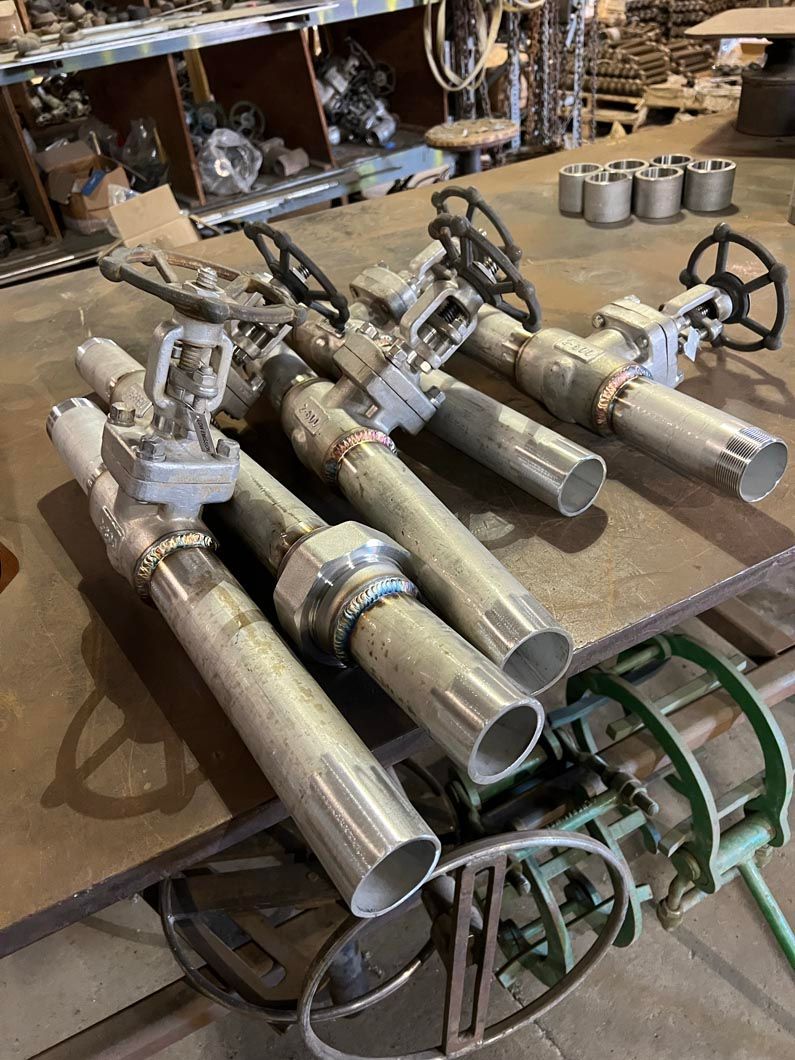 A bunch of pipes and valves are sitting on top of a table.