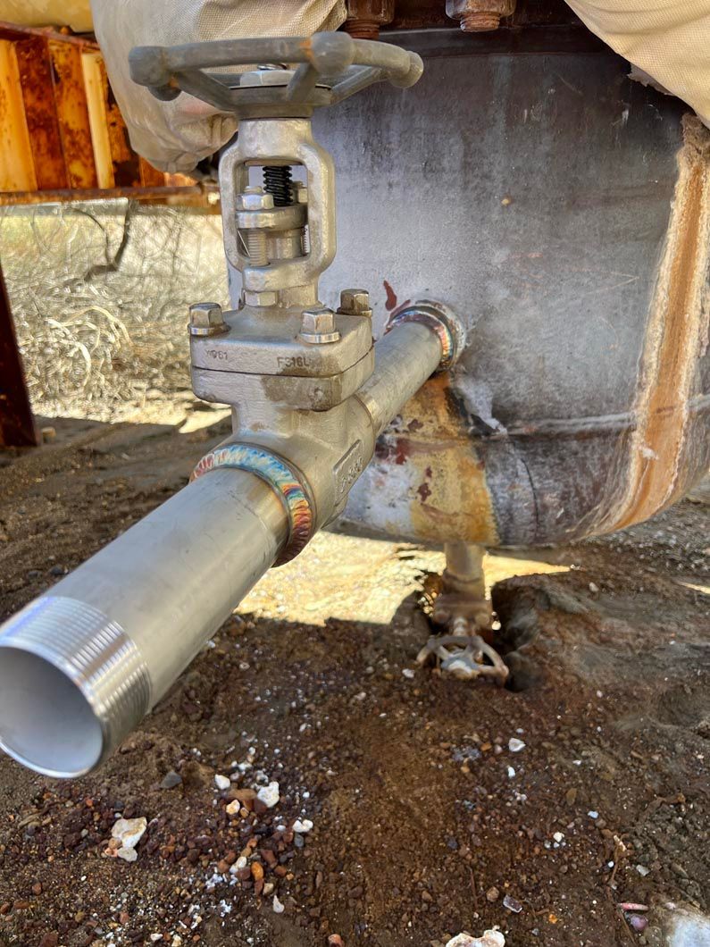 A close up of a pipe with a valve attached to it.