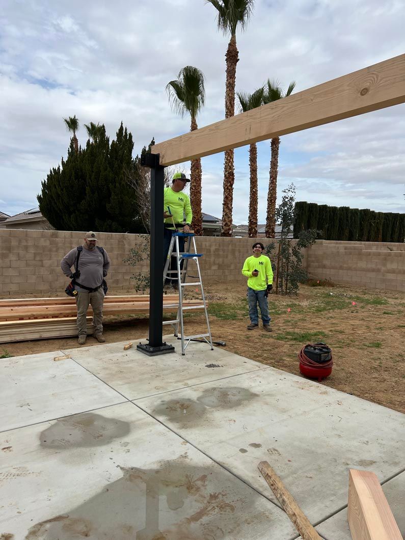 Two men are working on a wooden structure in a yard.